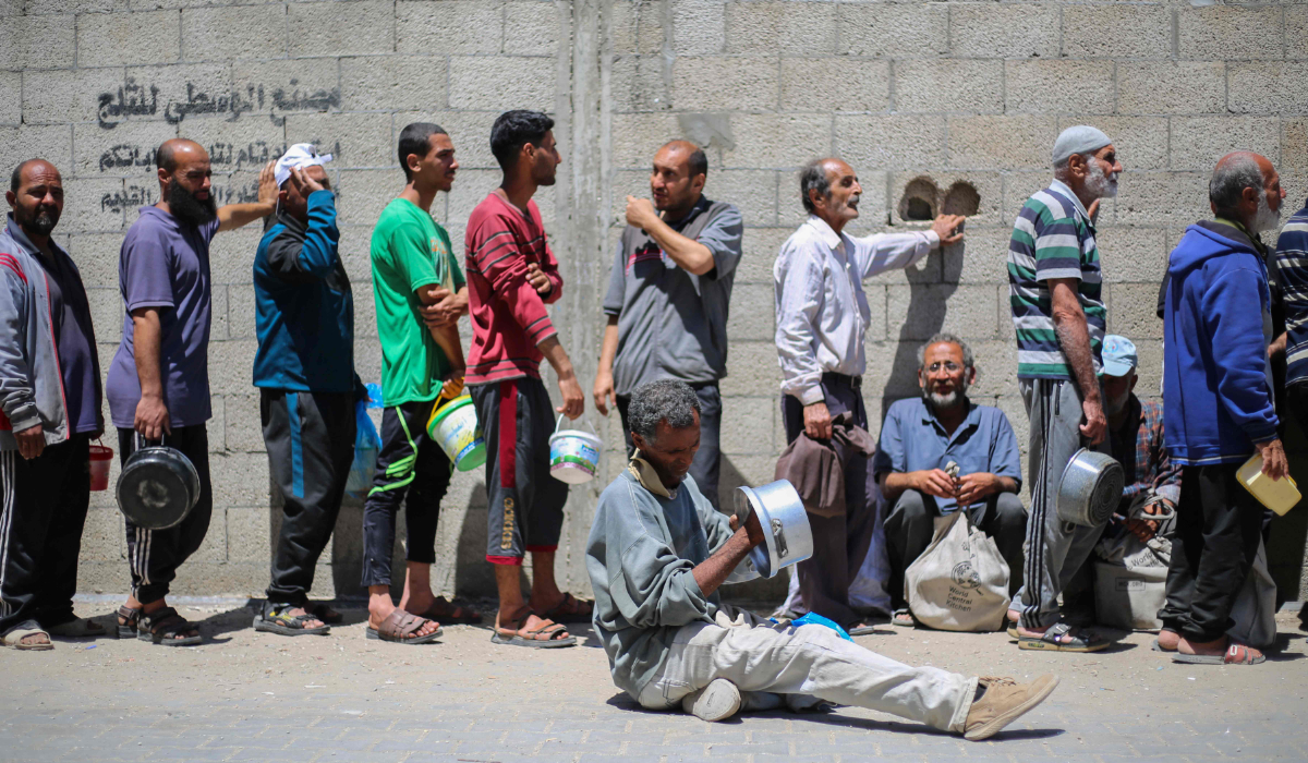 Palestinians queue for a hot meal at a charity kitchen run by the United Nation's World Food Programme (WFP) at the Nuseirat refugee camp in the central Gaza Strip on April 26, 2025. (AFP)
