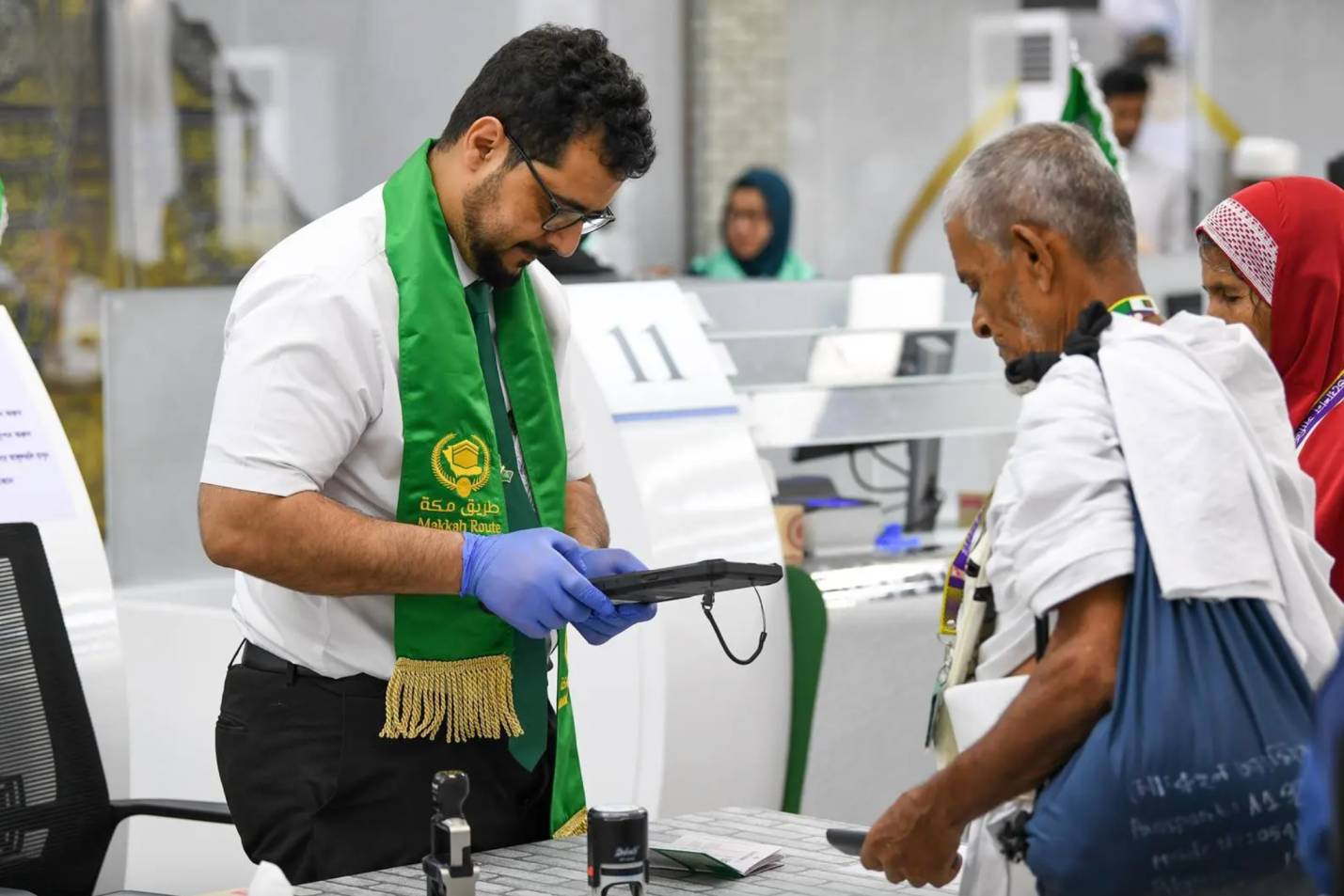 A Saudi immigration official processes Bangladeshi Hajj pilgrims departing from Dhaka under the Makkah Route Initiative on May 27, 2024. (SPA)