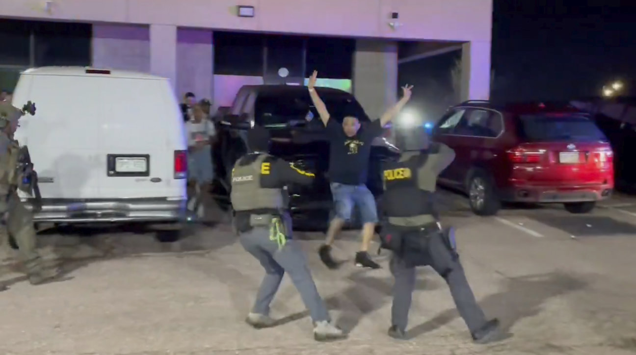 In this image taken from video released by the US Drug Enforcement Administration, officers stop a patron from a nightclub where a raid occurred Sunday, April 27, 2025, in Colorado Springs, Colo. (US Drug Enforcement Administration via AP)