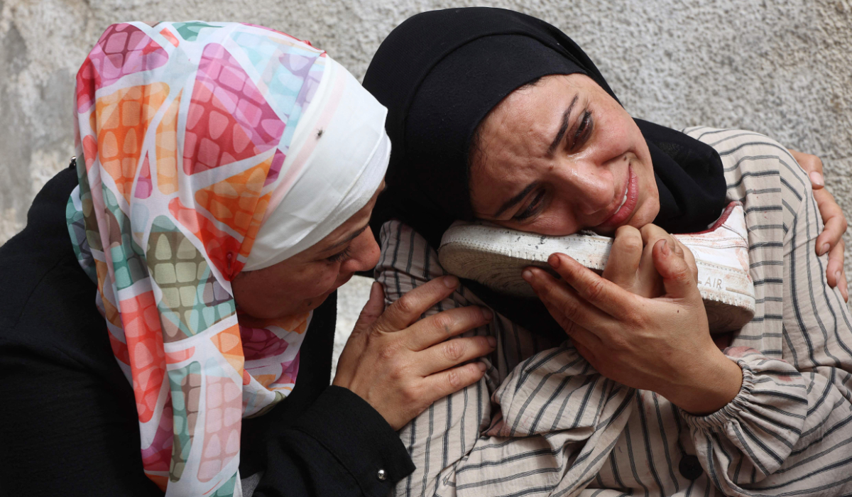 A Palestinian woman mourns as she holds the blood-stained shoe of a loved one, who was killed during an Israeli strike earlier on Al-Jalaa street, at Al-Shifa hospital in Gaza City, in the central Gaza Strip on April 28, 2025. (AFP)