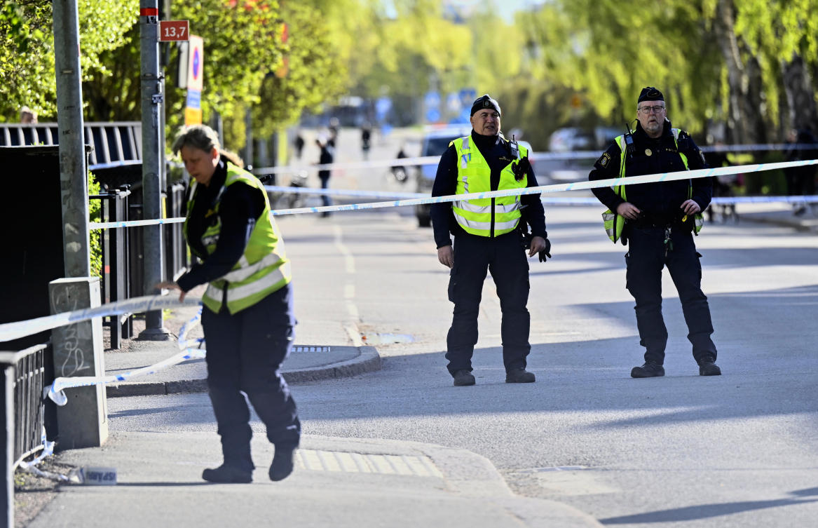 Police stand guard at the area were three people were killed in an earlier shooting at Vaksala Square in central Uppsala, Sweden on April 30, 2025. (TT News Agency via AP)