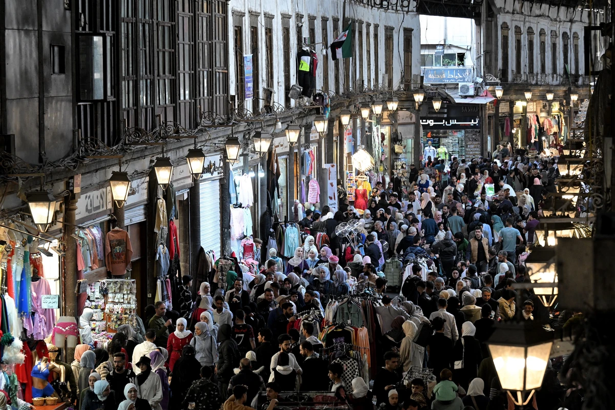 Shoppers walk browsing for items along the alley of Damascus' Hamidiya covered market, Mar. 29, 2025. (AFP)