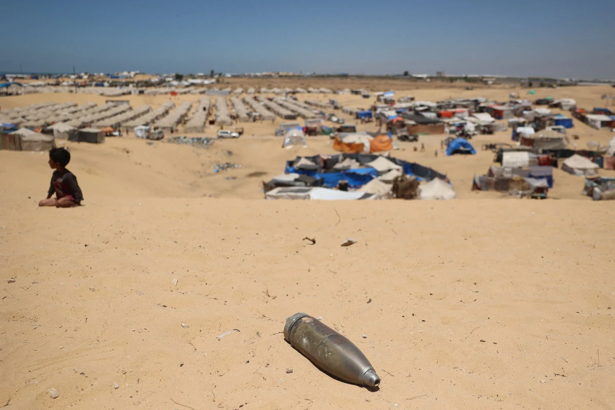 Civilians watch as Hamas ammunition experts collect unexploded ordnance found amid the rubble of destroyed buildings in the back of a pick in the eastern district of Khezaa in Khan Yunis in the southern Gaza Strip on November 24, 2023. (AFP)