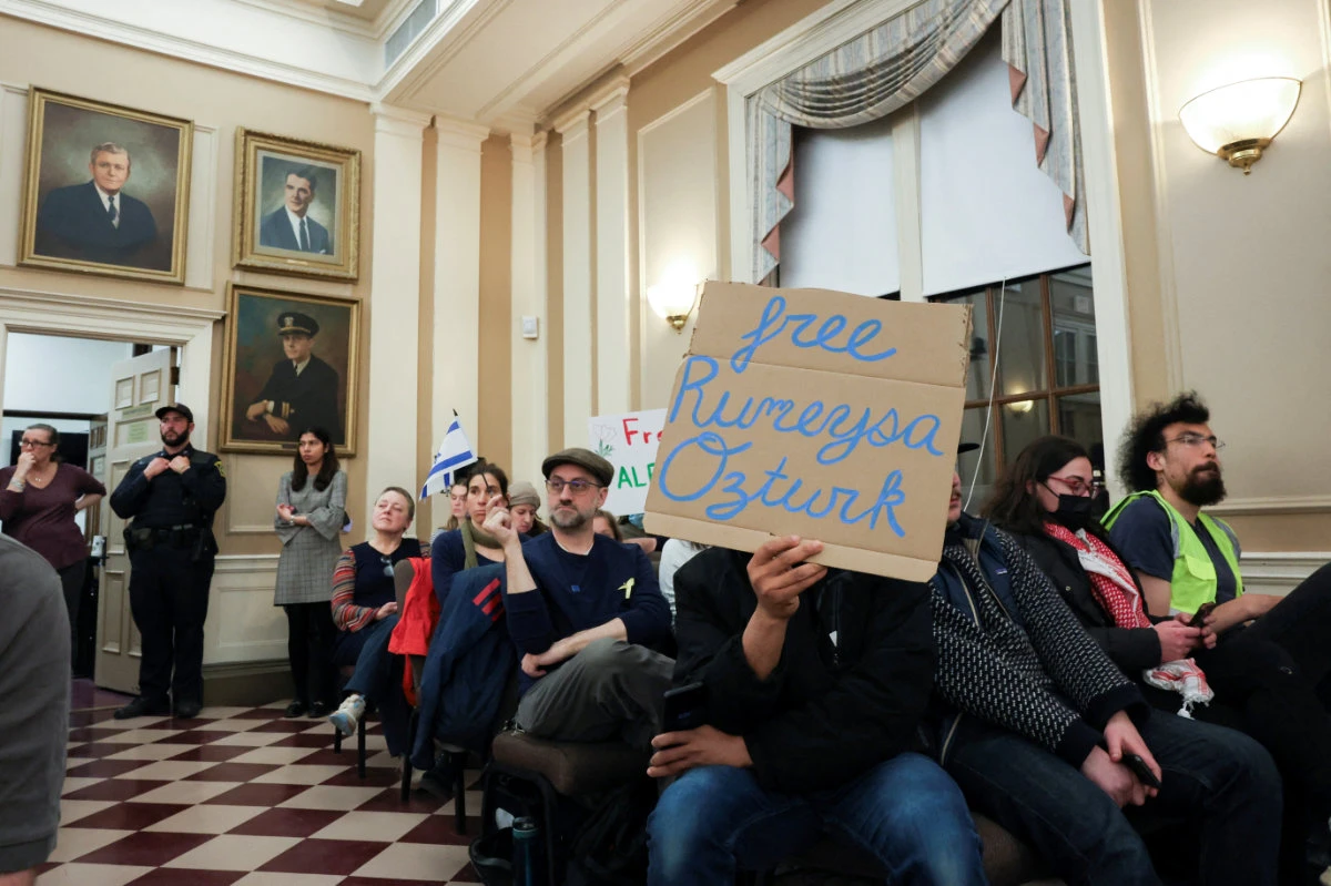 Demonstrators attend a city council meeting after Tufts Ph.D. student Rumeysa Ozturk was taken into custody by federal agents, in Somerville, Massachusetts, on March 27, 2025. (REUTERS)