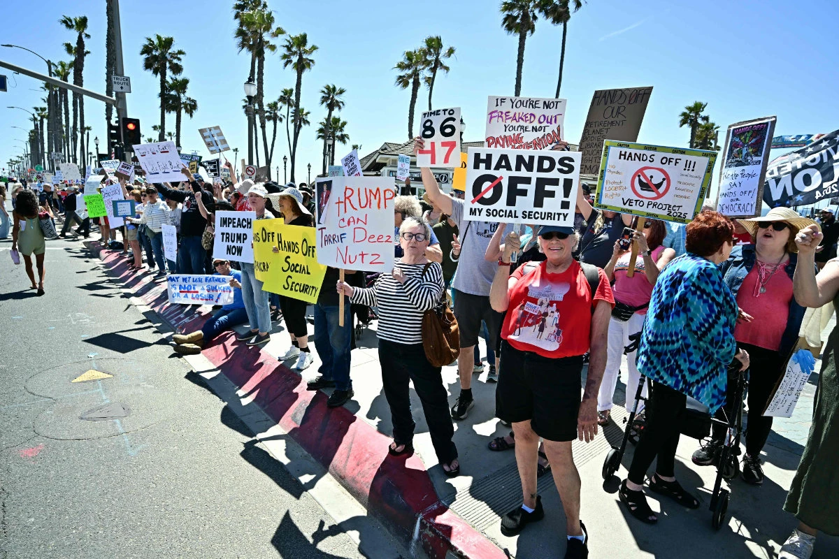 Demonstrators rally during the nationwide "Hands Off!" protest against US President Donald Trump and his adviser, Tesla CEO Elon Musk, in Huntington Beach, California, on April 5, 2025. (AFP)