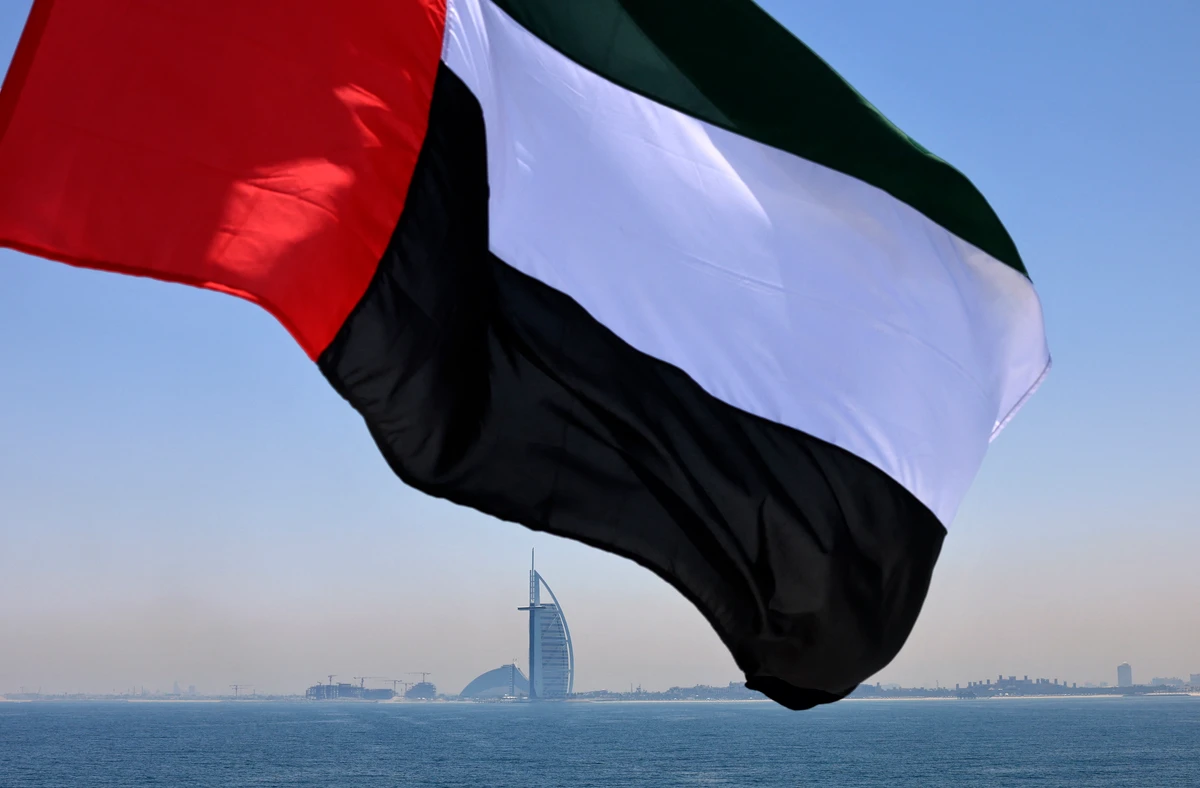 An Emirati flag fluttering above Dubai's marina with the Burj Al Arab landmark hotel in the background. (File/AFP)