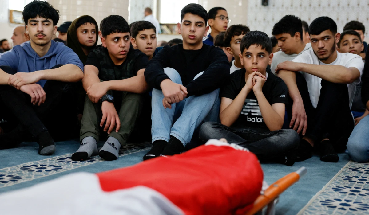 Youth mourn around the body of Palestinian-American boy Omar Mohammad Rabea, 14, who was killed by Israeli forces in Turmus Ayya village, during his funeral, near Ramallah in the Israeli-occupied West Bank April 7, 2025. (REUTERS)