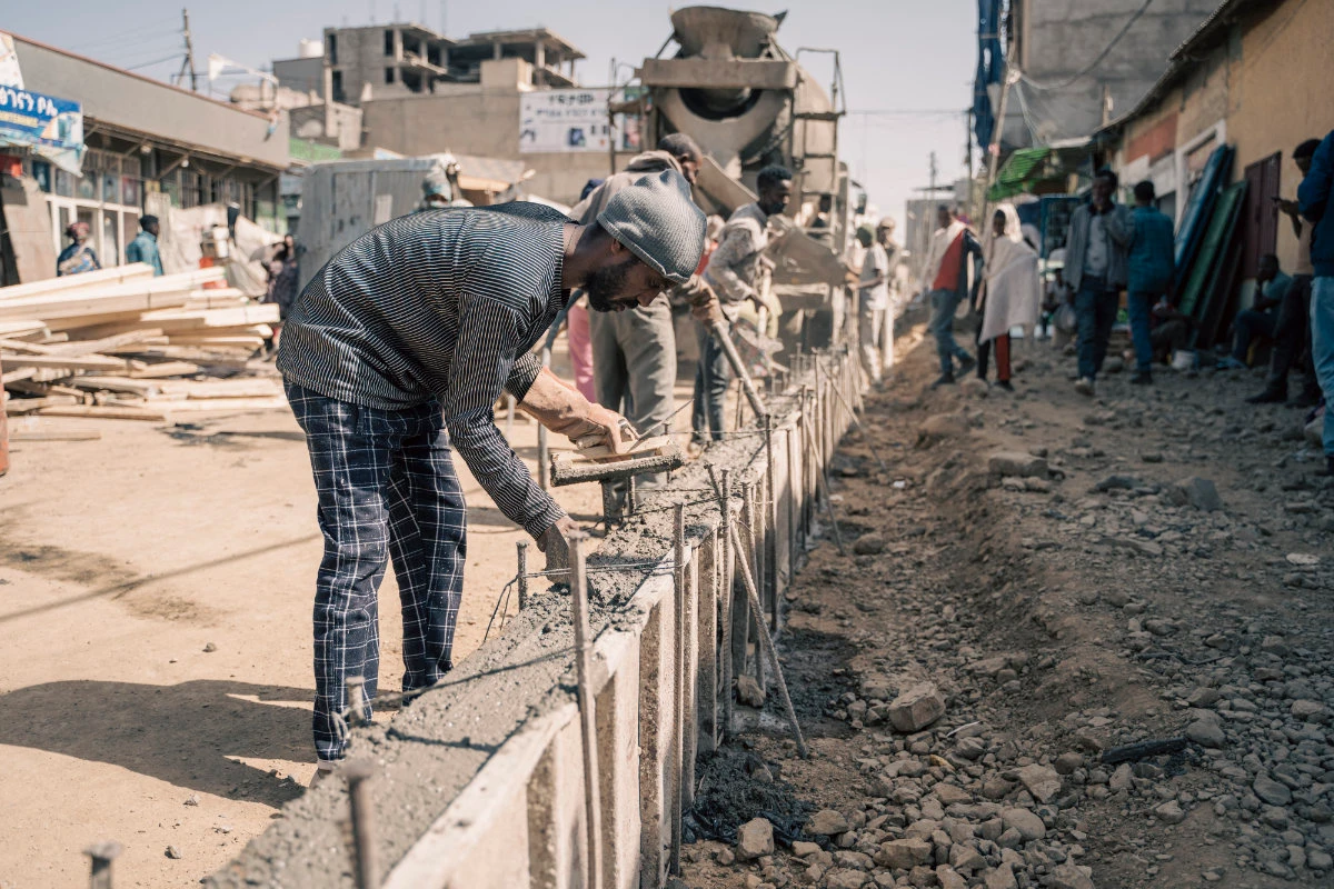 Construction workers fill in a street pavement for a side walk in a newly built road in Mekele, Ethiopia, on May 24, 2024. Amnesty International has called on the Ethiopian government to look into the massive evictions taking place as it carries out its street renovation and widening projects in cities across the country. (AFP)