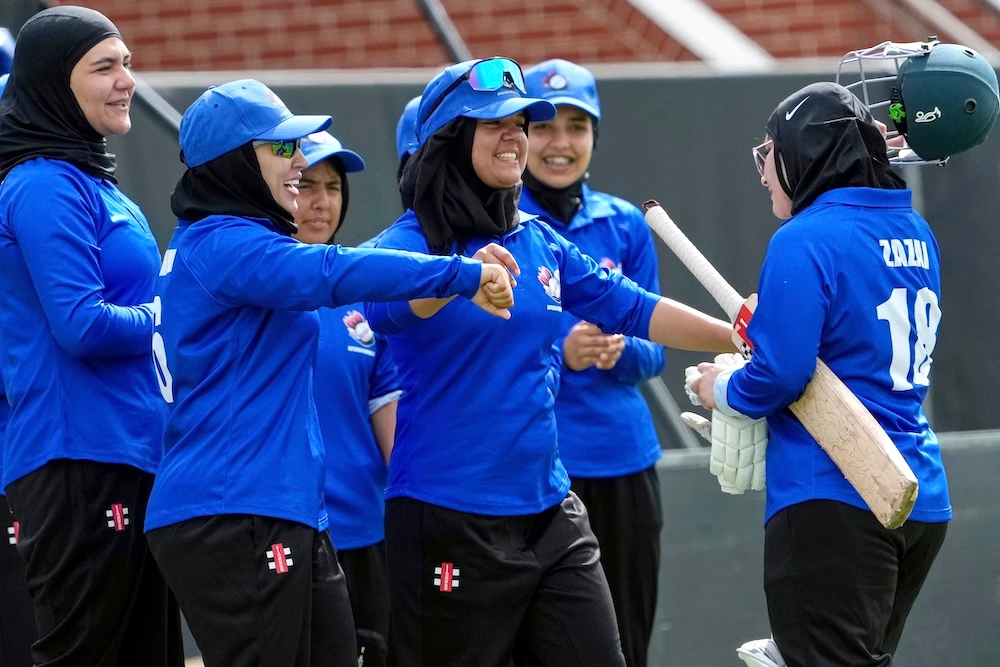 Afghan players congratulate top scoring batter Zazai as she walks off the field during their match against Cricket Without Borders XI at Junction Oval, Melbourne, on Jan. 30, 2025. (AP)