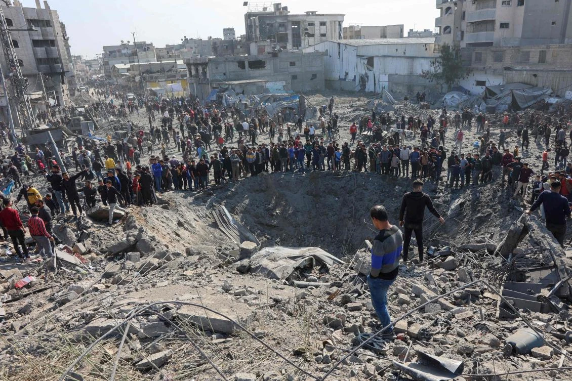 Palestinians gather around a large crater following an Israeli strike on a metalsmith workshop at the Zaytoun neighbouhood in Gaza City on April 13, 2025. (AFP)