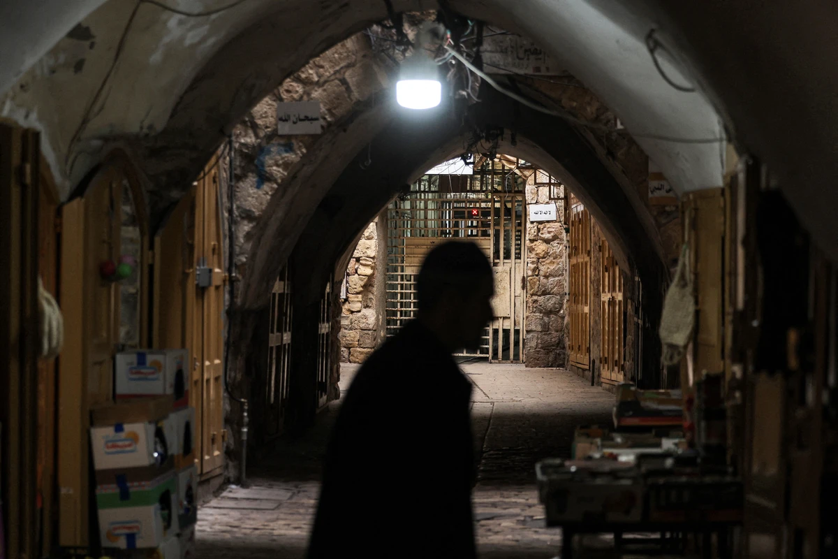 A man walks along an alley near the entrance of the Ibrahimi Mosque in the city of Hebron in the occupied West Bank, Apr. 15, 2025. (AFP)