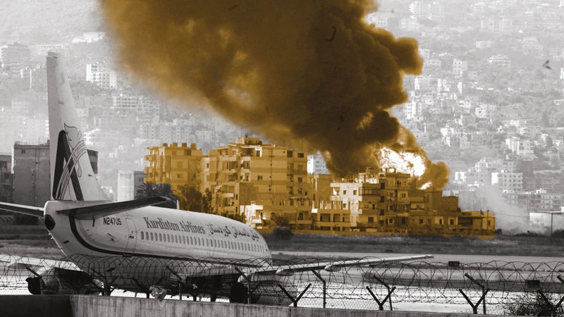 A plane sits on the tarmac while flames rise from fuel tanks at Beirut International Airport after an Israeli airstrike in July 2006. AFP