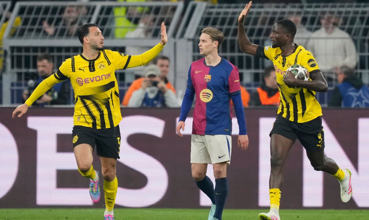 Dortmund's Serhou Guirassy, right, celebrates with Dortmund's Ramy Bensebaini after scoring the opening goal during the Champions League quarterfinals second leg soccer match between Borussia Dortmund and Barcelona, at the Signa-Iduna Park in Dortmund, Germany, Tuesday, April 15, 2025. (AP)