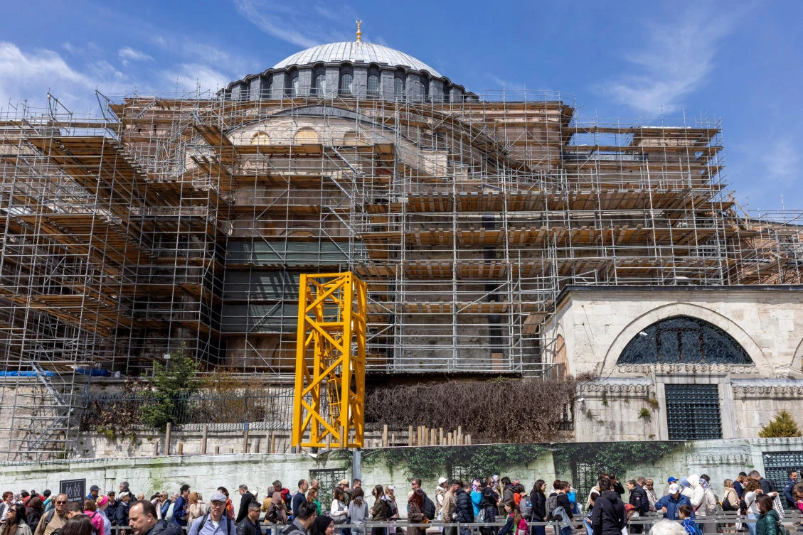 Tourists and worshippers stand in a queue outside Ayasofya-i Kebir Cami-i Serifi or Hagia Sophia Grand Mosque, while Turkiye begins restoration work on dome of Hagia Sophia, as part of a larger effort to reinforce the structure and conserve its mosaics, in Istanbul, Turkiye, April 14, 2025. (REUTERS)