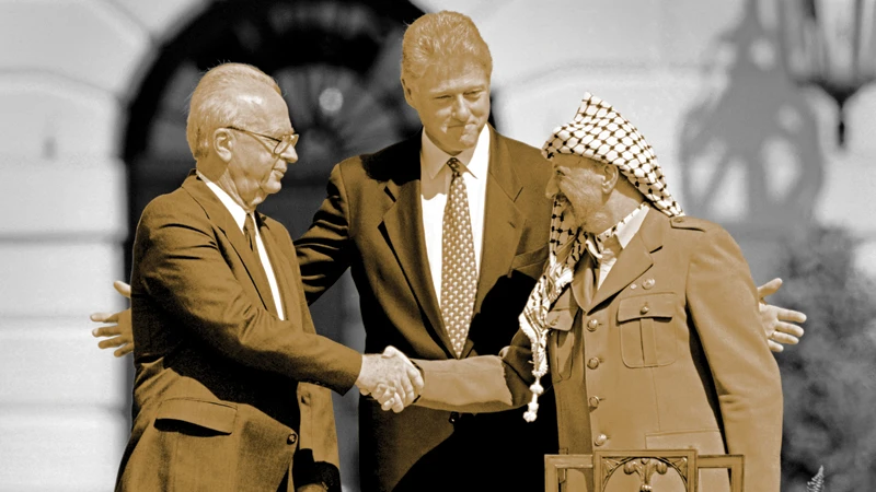 US President Bill Clinton stands between PLO leader Yasser Arafat (R) and Israeli PM Yitzahk Rabin as they shake hands for the first time after signing the Oslo Accords. AFP