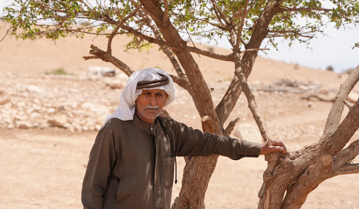 70-year-old Palestinian, Odeh Amareen Bedouin, stands near a tree in Al-Ouja, near Jericho in the Israeli-occupied West Bank, April 15, 2025. (REUTERS)
