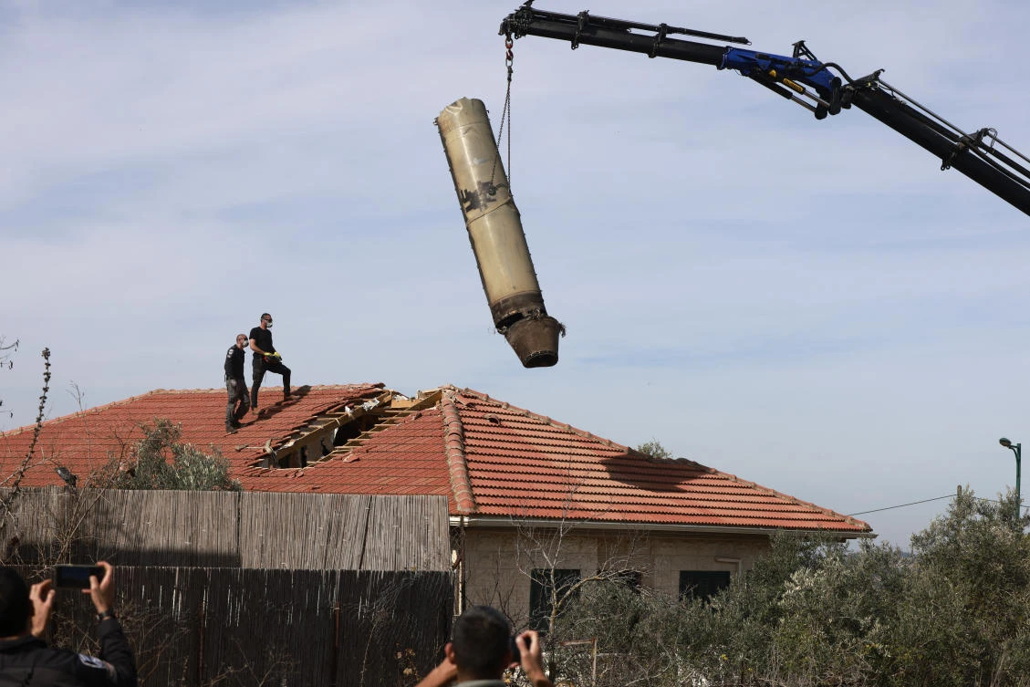 Israeli security officers oversee the removal of a part of a missile fired from Yemen. (File/AFP)
