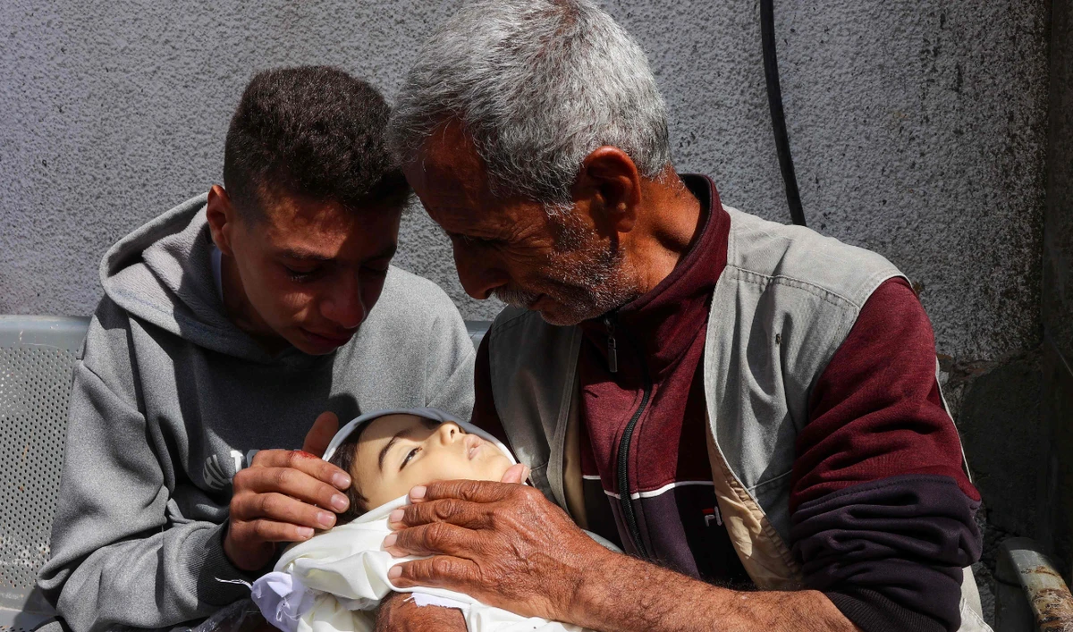 Palestinians mourn the loss of a child at Al-Shifa Hospital on Monday. (AFP)