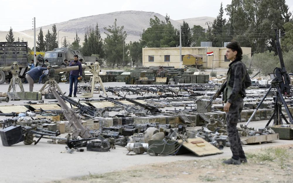 Jaish Al-Islam fighters hand over weapons to the Syrian government forces in Al-Dumayr, some 50 kilometers east of Damascus on April 22, 2018 under a deal struck with the then Russian-backed regime. (AFP file photo)