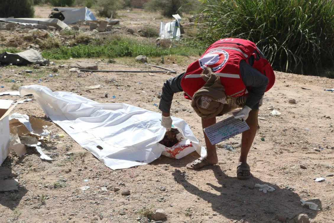 A Yemeni Red Crescent rescuer covers the body of a victim pulled from the rubble of a building hit in US strikes in the northern province of Saada, Apr. 28, 2025 (AFP)