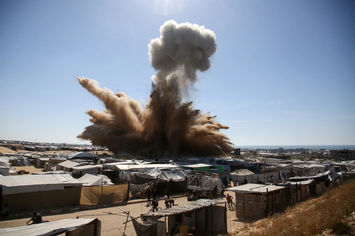 Smoke rises above tents at a camp for displaced Palestinians during an Israeli strike in Khan Younis. April 19, 2025 (AFP)