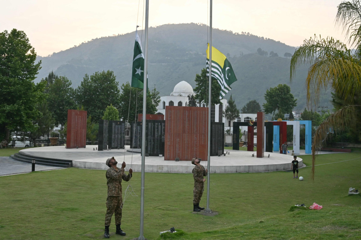 Pakistani army soldiers lower down Pakistani and Kashmiri flags on the martyr monument park during sunset in Muzaffarabad, the capital of Pakistan-controlled Kashmir, on April 30, 2025, amid border tensions with India. (AFP)