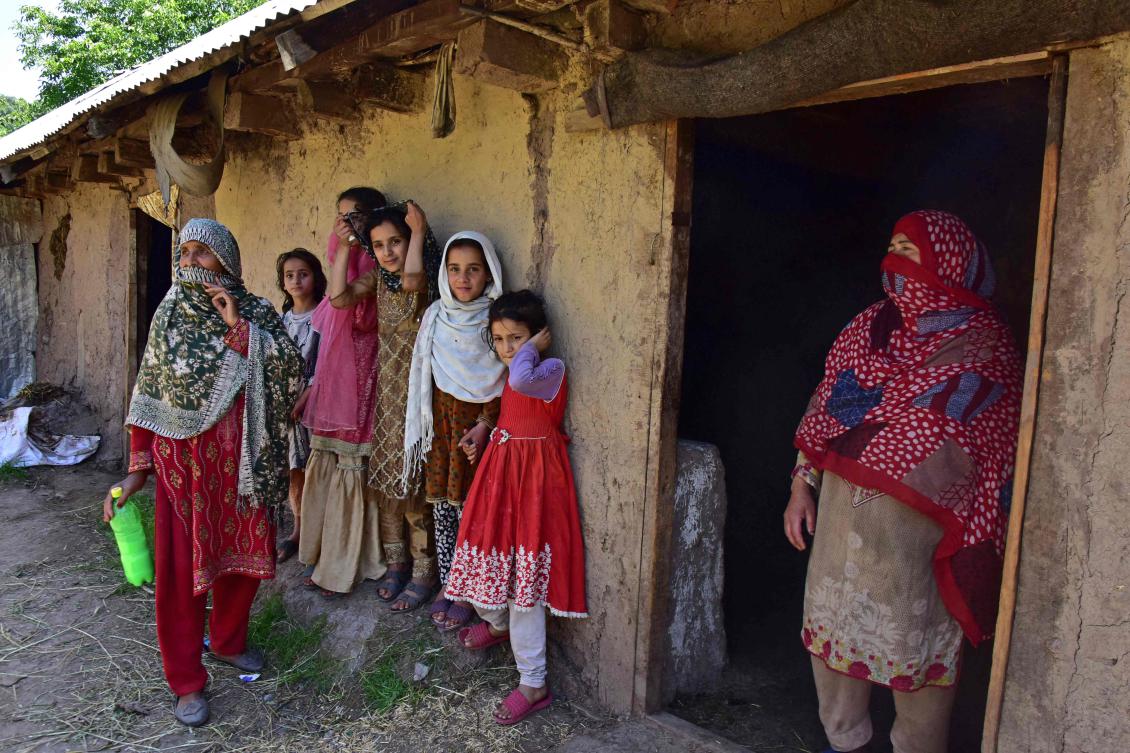 Pakistan-administered Kashmir called on residents to stockpile food on Friday as tensions flare with India. Above, local women stand outside their house comprising of an underground bunker in the Chakothi village of Pakistan-administered Kashmir. (AFP)