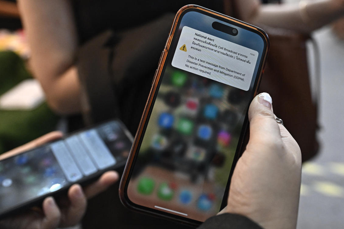 A test message from Thailand's Department of Disaster Prevention and Mitigation (DDPM) is seen on a mobile phone during a test run for an emergency cell broadcast system. (File/AFP)