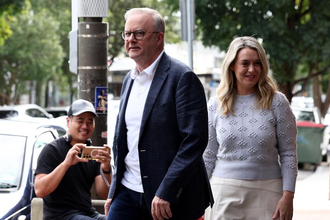 Australia's re-elected Prime Minister Anthony Albanese and his partner Jodie Haydon walk in the streets as they visit a cafe in Sydney. (File/AFP)