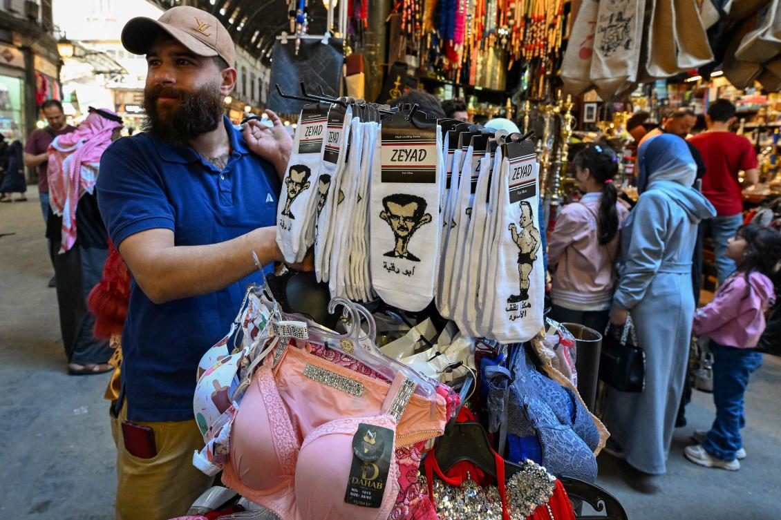 A man looks at socks bearing caricatures of ousted Syrian leader Bashar al-Assad at a store in Damascus on May 5, 2025.(AFP)