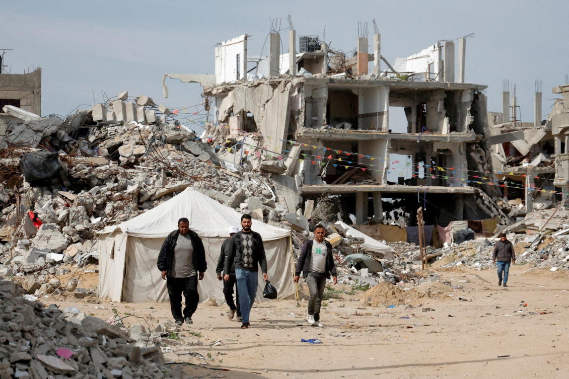 FILE PHOTO: Palestinian men walk near rubble of houses destroyed during the Israeli offensive, in Rafah, in the southern Gaza Strip, March 13, 2025. (Reuters)