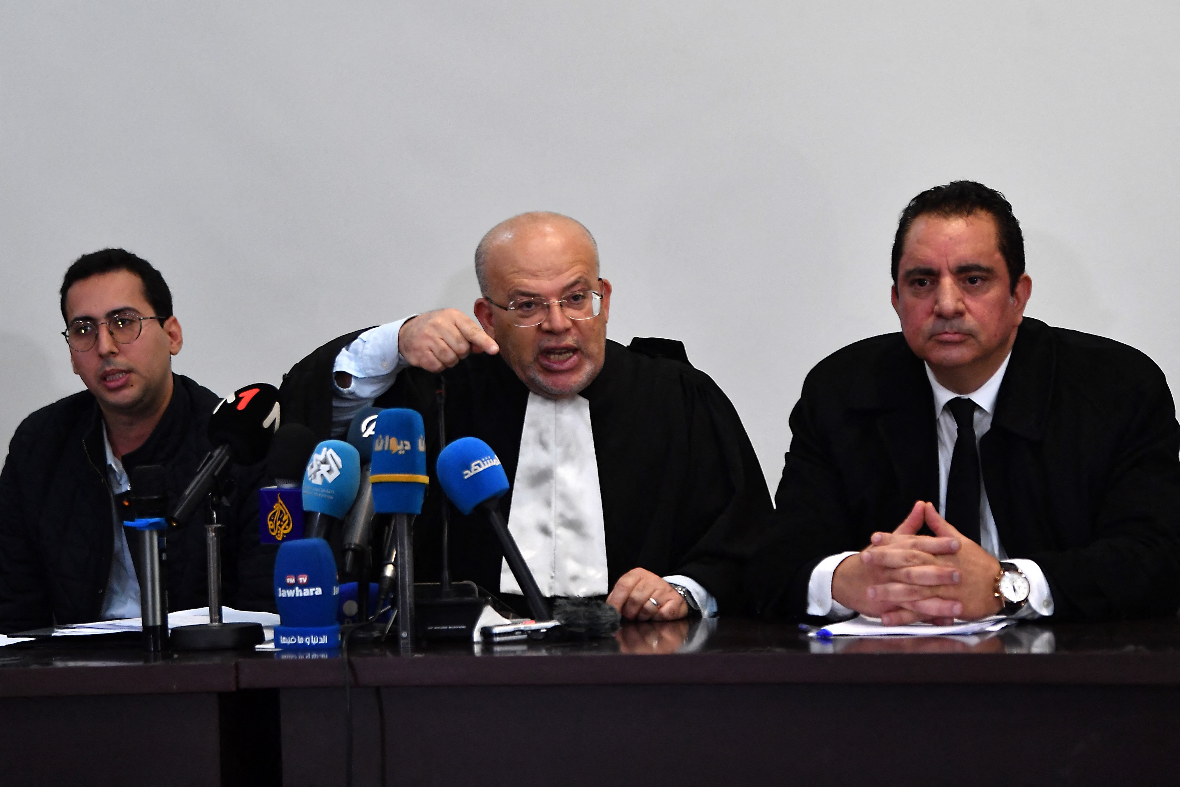 Samir Dilou (C), lawyer and member of the defence committee of detainees accused of involvement in a conspiracy case against state security, talks to reporters in front of the court in Tunis, Apr. 21, 2025. (AFP)