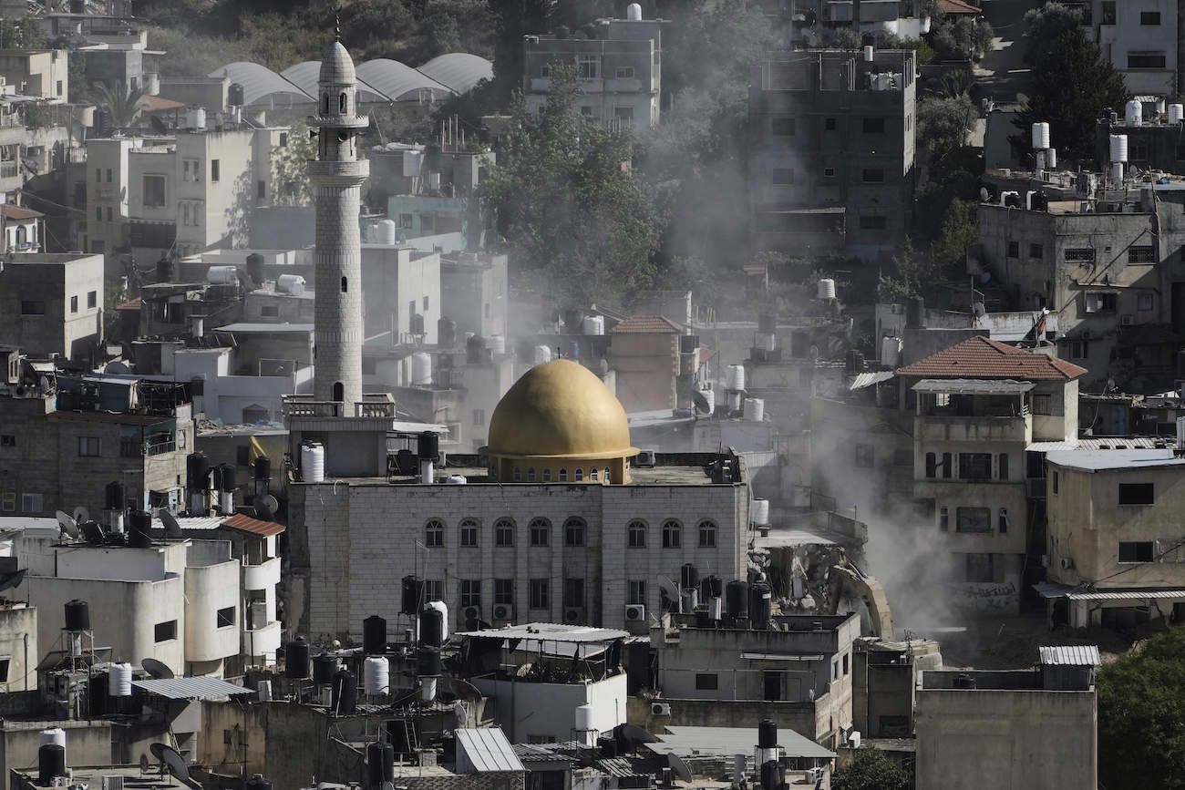 An Israeli army bulldozer demolishes homes next to a mosque in the Palestinian urban refugee camp of Nur Shams, in the West Bank, Tuesday, May 6, 2025. (AP)
