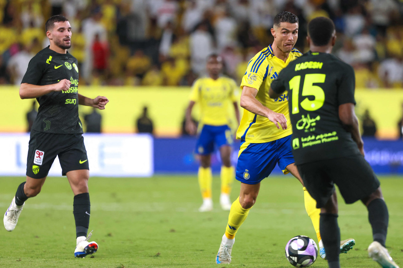 Nassr's Portuguese forward #7 Cristiano Ronaldo is marked by Ittihad's Saudi defender #15 Hassan Kadesh during the Saudi Pro League football match between Al-Nassr and Al-Ittihad at Al-Awwal Park in Riyadh on May 7, 2025. (AFP)