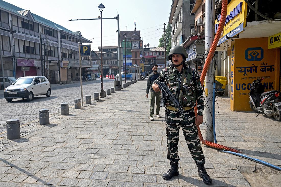 An Indian paramilitary personnel stands guard near closed shops along a partially deserted street at the Lal Chowk in Srinagar. (File/AFP)