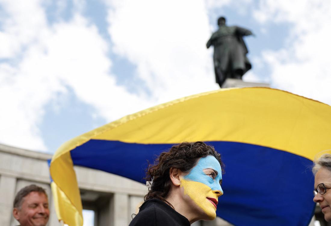 A Ukraine supporter with her face painted in Ukraine's colours stands with a Ukraine flag at the Soviet War Memorial Tiergarten. (File/AFP)