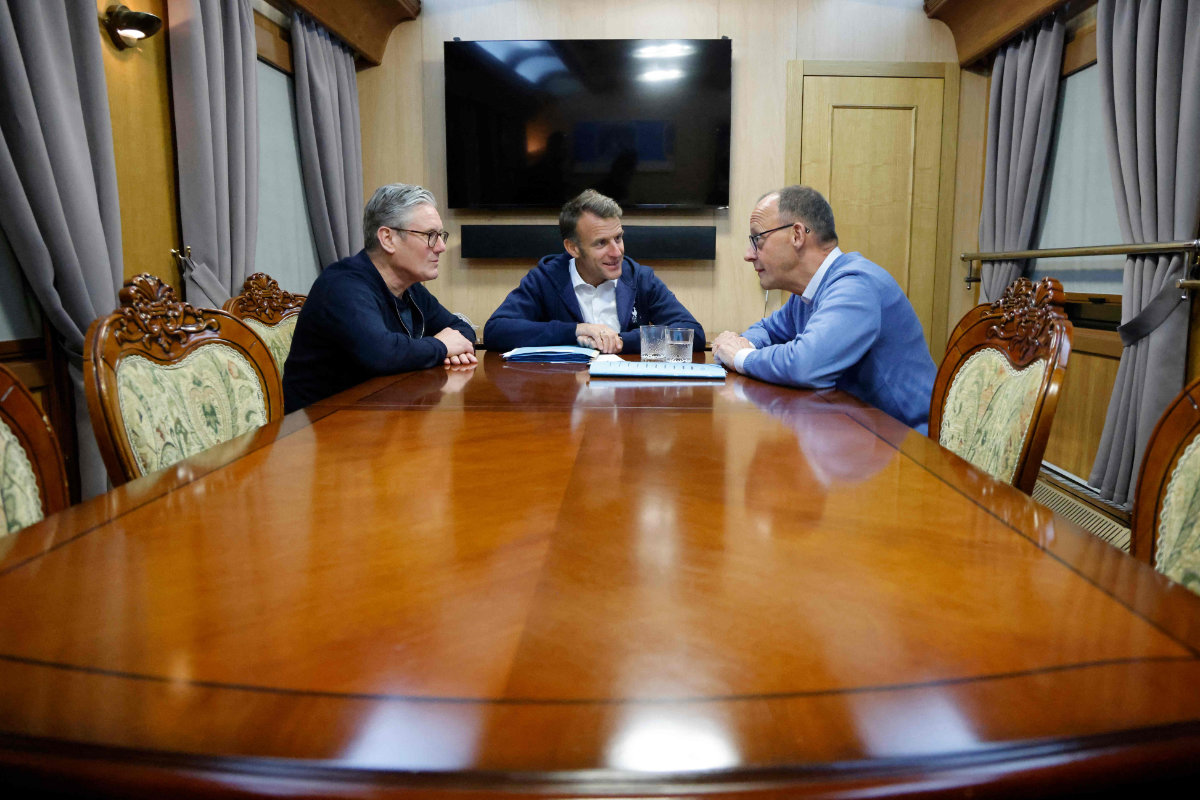 France's President Emmanuel Macron (C), Britain's Prime Minister Keir Starmer (L) and German Chancellor Friedrich Merz (R) hold a trilateral meeting on board a train to Ukraine from Poland on May 9, 2025. (POOL / AFP)