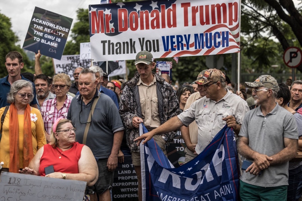 White South Africans supporting US President Donald Trump and South African and US tech billionaire Elon Musk gather in front of the US Embassy in Pretoria. (AFP/File)