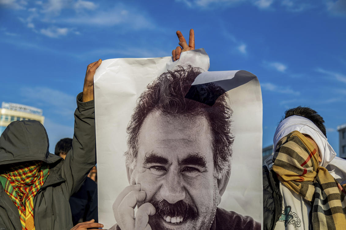 Youngsters hold a photograph of the jailed leader of the rebel Kurdistan Workers' Party, or PKK, Abdullah Ocalan as they gather to watch live on a tv screen a Pro-Kurdish Peoples' Equality and Democracy Party, or DEM, delegation members releasing an statement from Ocalan, in Diyarbakir, Turkey, Thursday, Feb. 27, 2025. (AP)