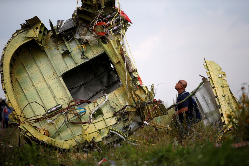A Malaysian air crash investigator inspects the crash site of Malaysia Airlines Flight MH17. (Reuters/File)