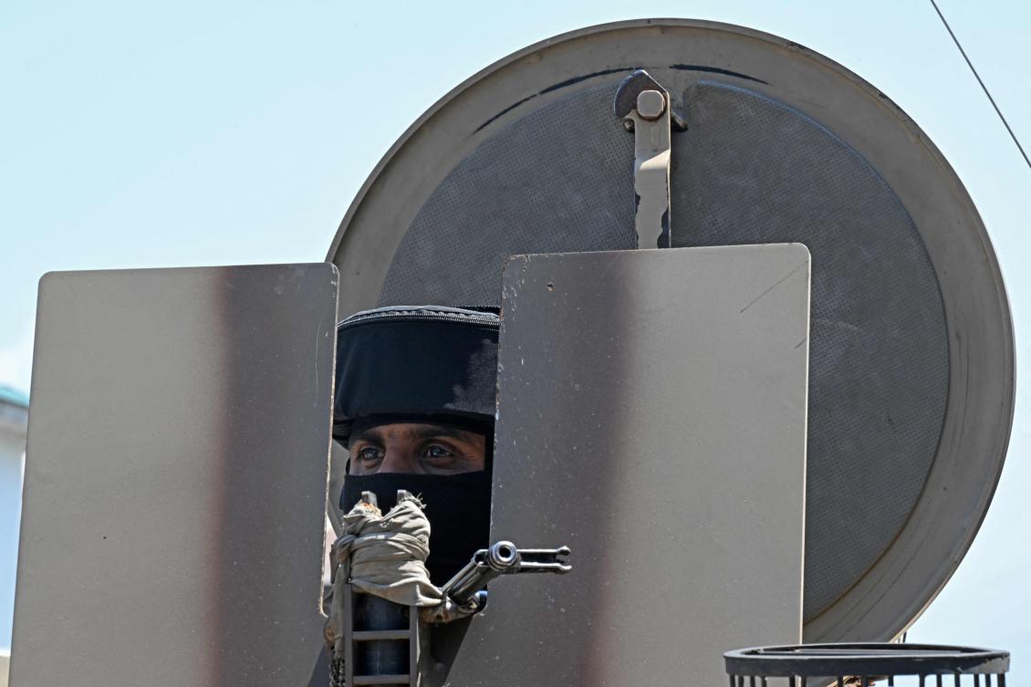 An Indian paramilitary trooper stands guard on an armoured vehicle parked along a street in Srinagar on May 15, 2025.(AFP)