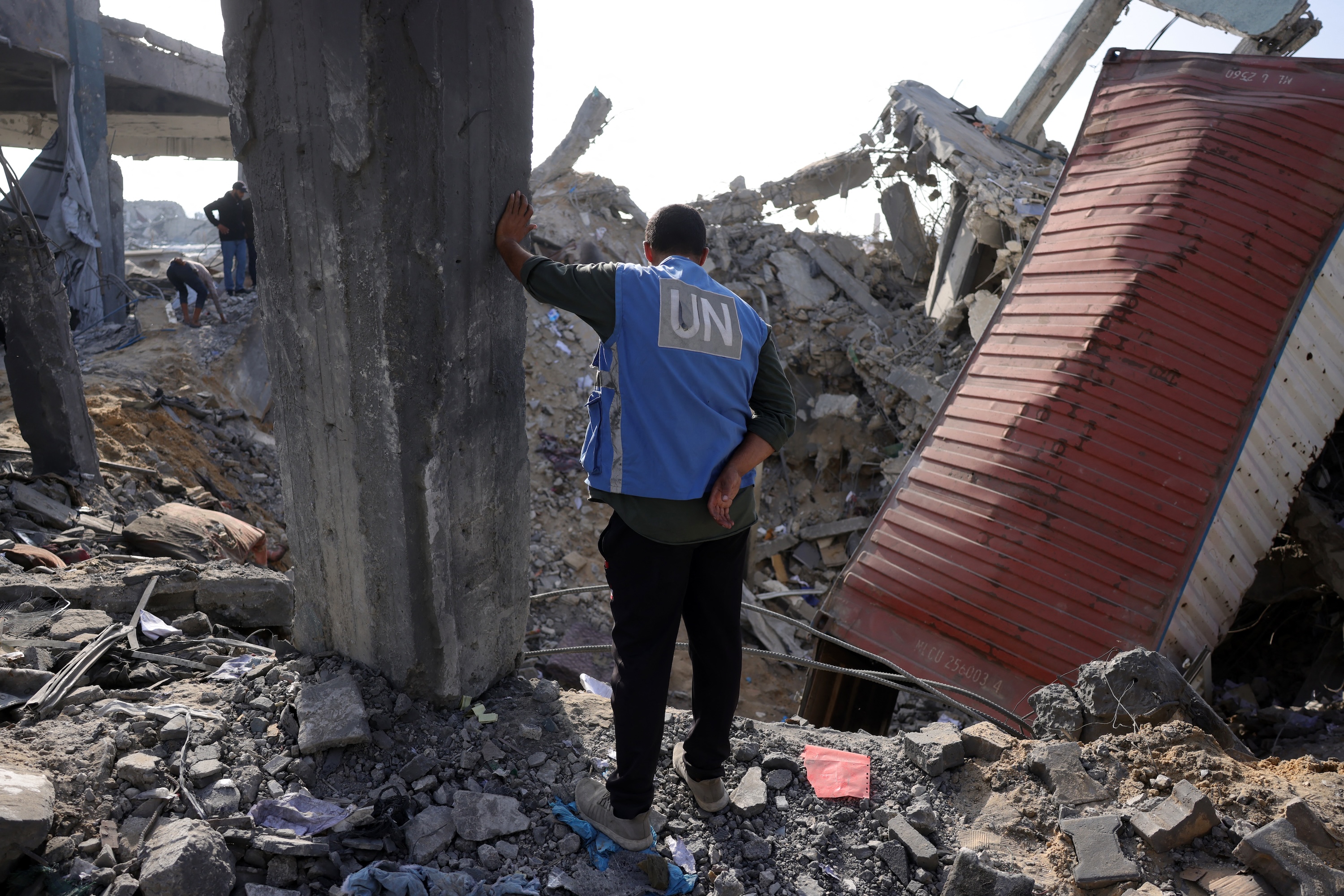 A UN worker stands amid the rubble of an UNRWA aid supply depot and shelter, heavily damaged in an overnight Israeli strike in Jabalia in the northern Gaza Strip, May 10, 2025. (AFP)