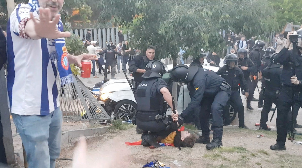 Police officers in riot gear assist a person following an incident in which a car drove into the crowd near the RCDE Stadium in Barcelona, Spain, on May 15, 2025, in this screen grab from a social media video. (@edumasllorens/via REUTERS )