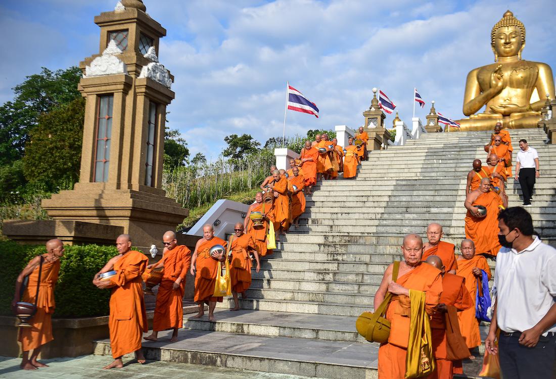 Buddhist monks arrive to receive offerings from devotees near a giant Buddha statue during an event to mark Makha Bucha Day in the southern Thai town of Narathiwat. (File/AFP)