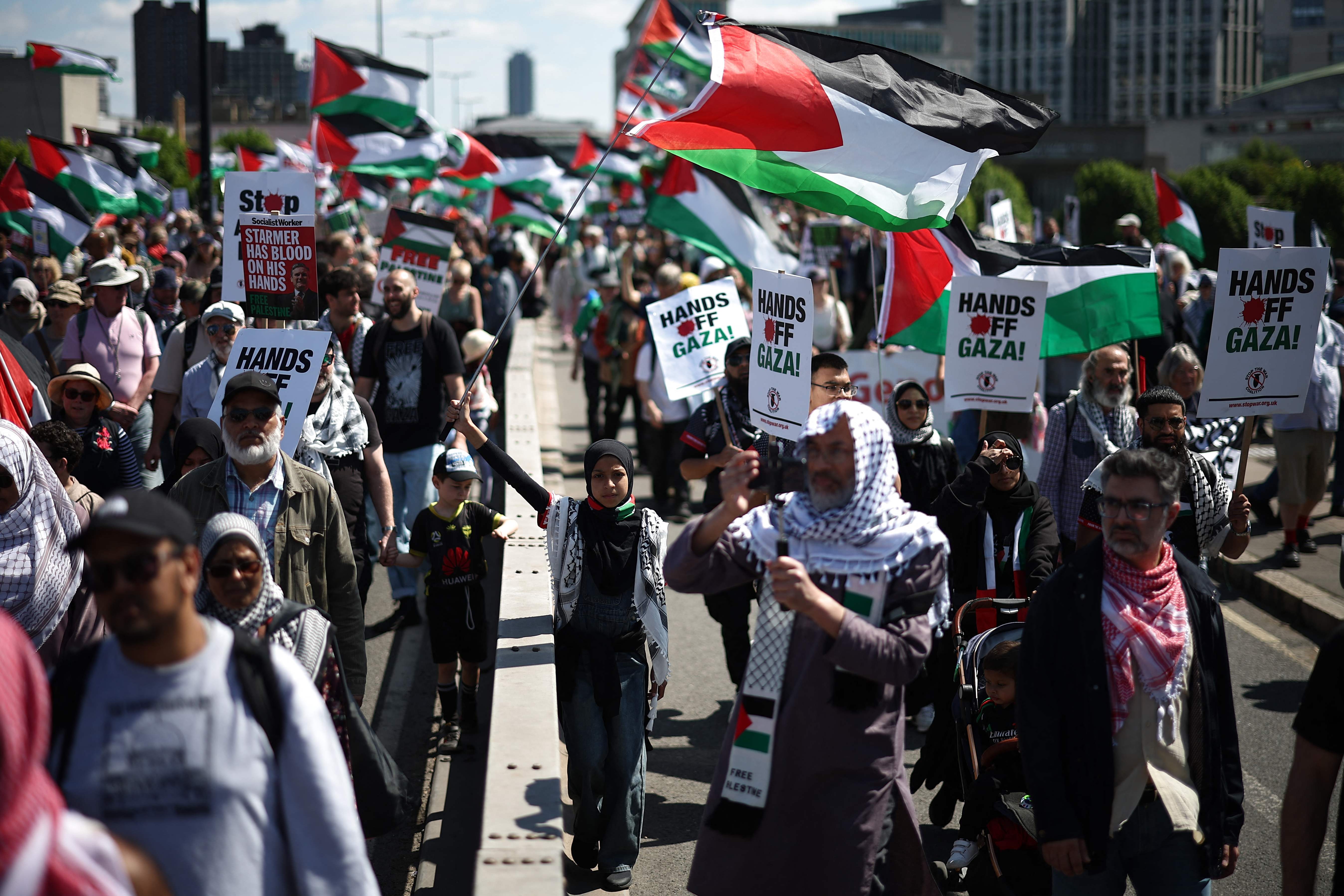Pro-Palestinian supporters wave Palestinian flags as they march across Waterloo Bridge in central London, on May 17, 2025. (AFP)
