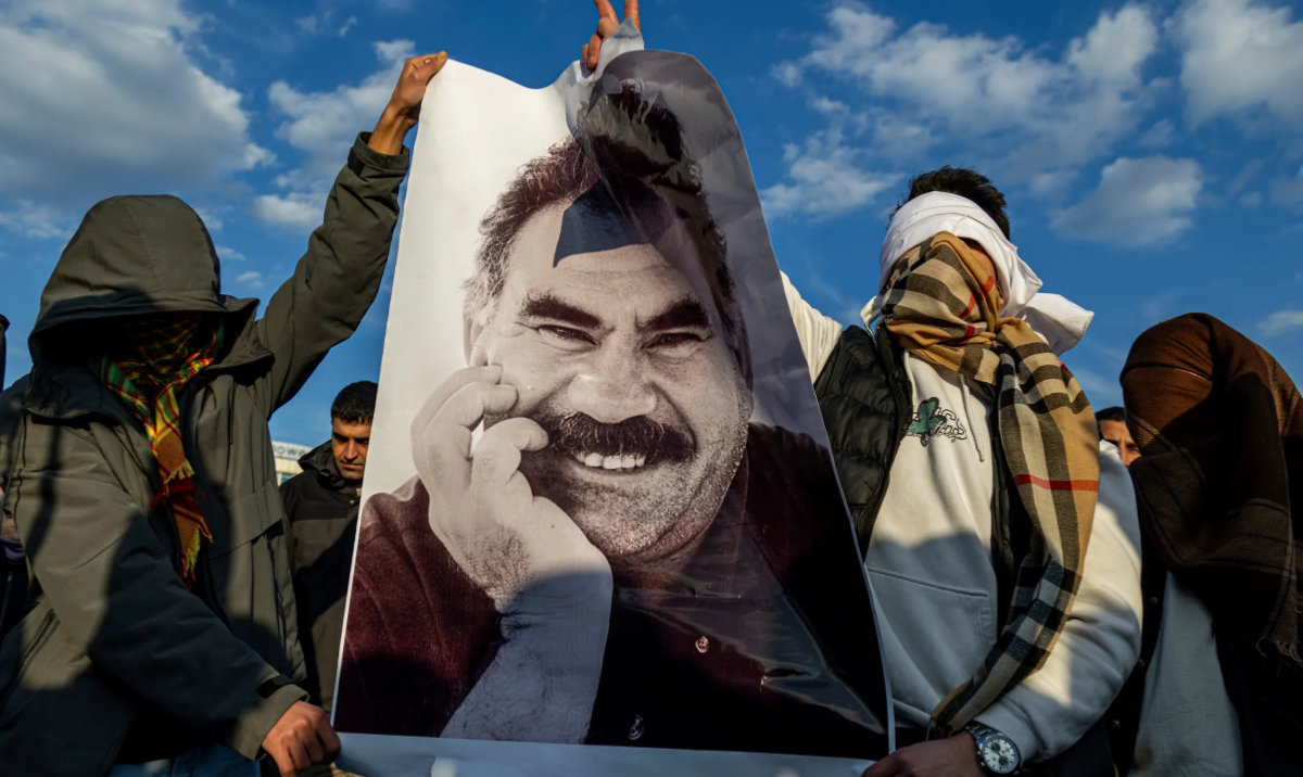 Youngsters hold a photograph of Abdullah Ocalan, the jailed leader of the militant Kurdish group, or PKK, in Diyarbakir, Turkiye, Feb. 27, 2025. (AP)