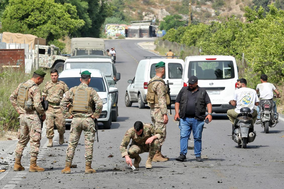 Lebanese army soldiers inspect a crater following an Israeli drone strike that targeted a car in Abu al-Aswad in southern Lebanon on May 17, 2025.(AFP)