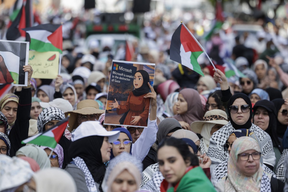 A protester lifts a placard bearing a depiction of Moroccan Microsoft engineer Ibtihal Abu Al-Saad after a widespread social media video showed her protesting the US company's reported supply of AI technology to Israel in its ongoing war in Gaza, during a national march in support of Palestinians and against Morocco's normalisation of ties with Israel, in the capital Rabat on April 6, 2025. (AFP)