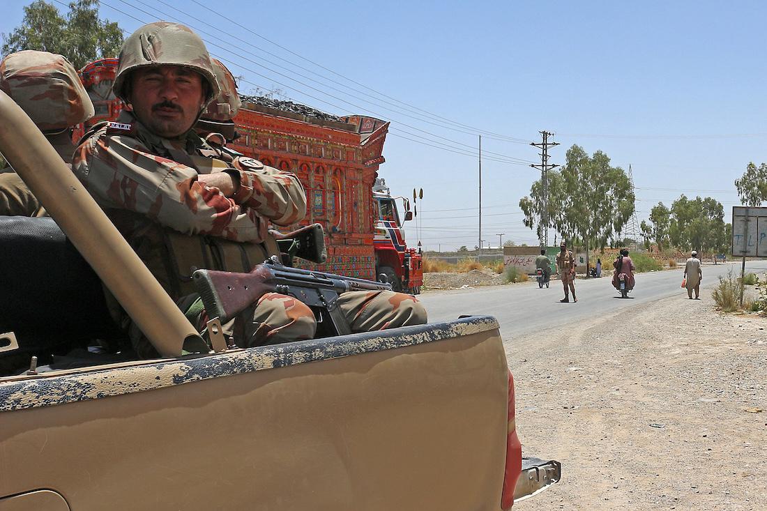 Security personnel guard along a street near the site of a school bus bombing in the Khuzdar district of Balochistan province . (File/AFP)