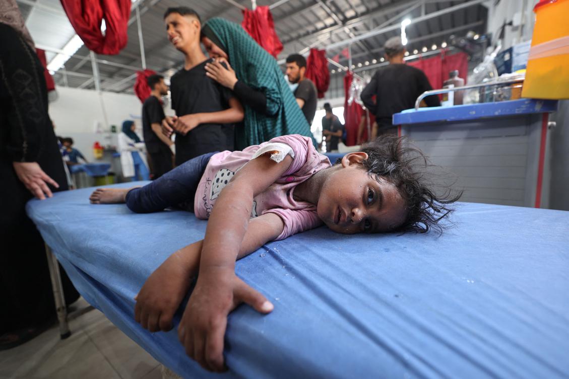A woman and a child cry as a little girl lies on a hospital bed waiting for first aid treatment at Al-Awda Hospital in Gaza. (AFP)